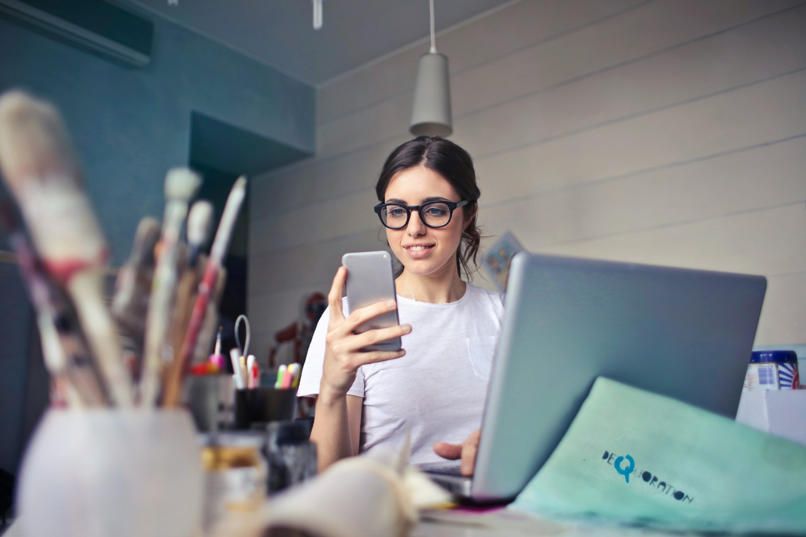 woman looking at her phone while working