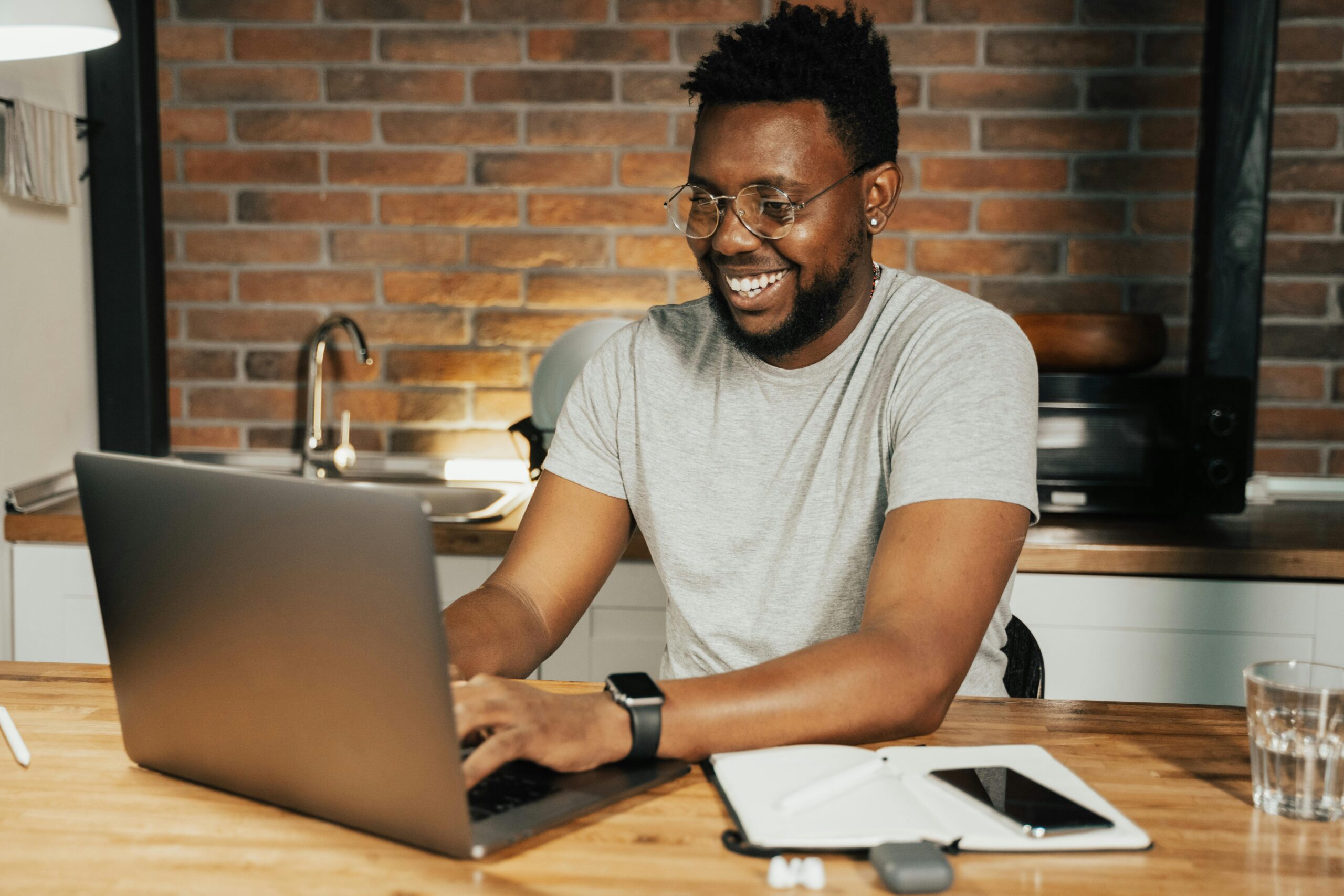 man smiling at his laptop