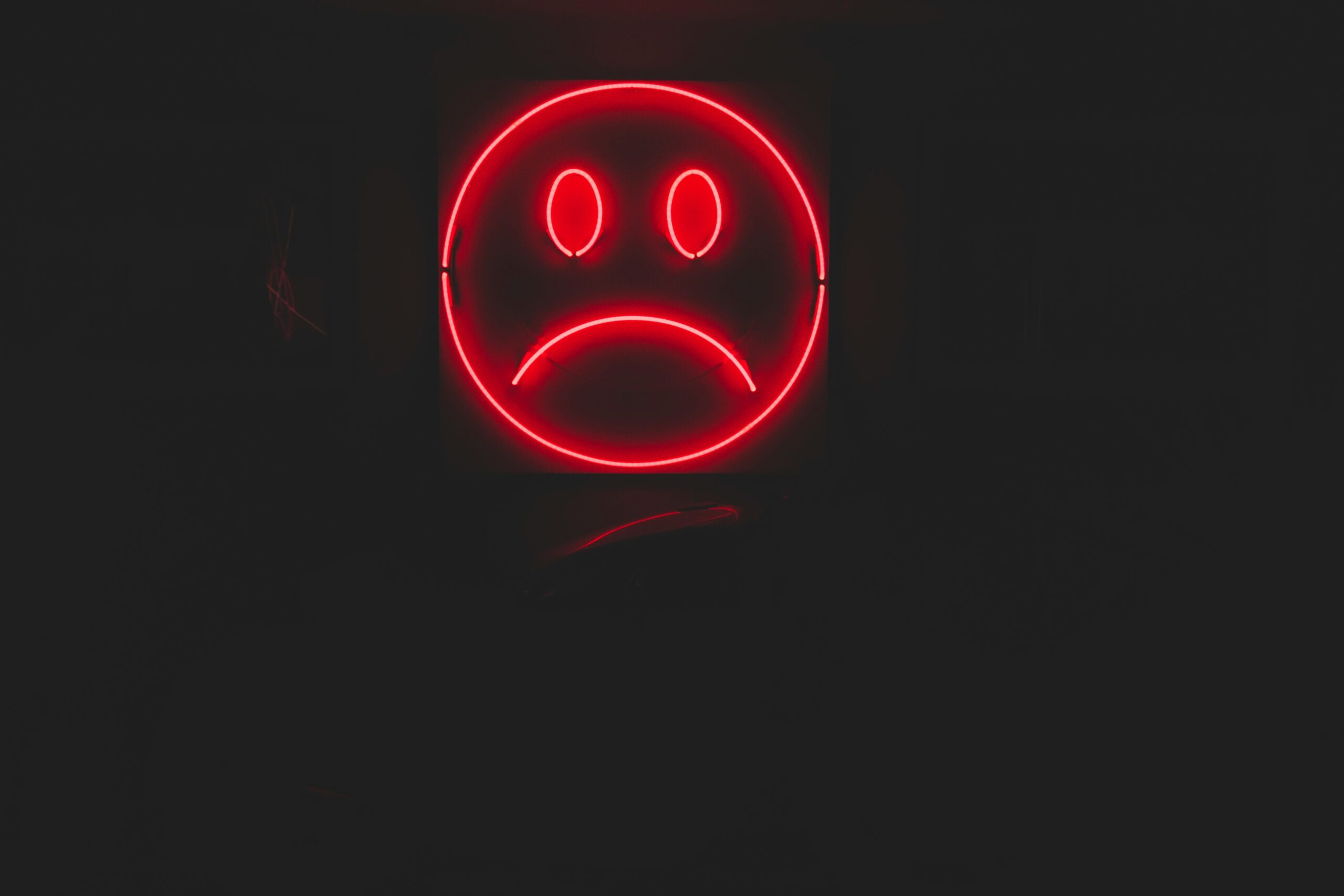 neon sign with sad face