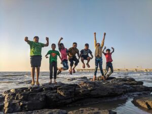children at the beach jumping for joy