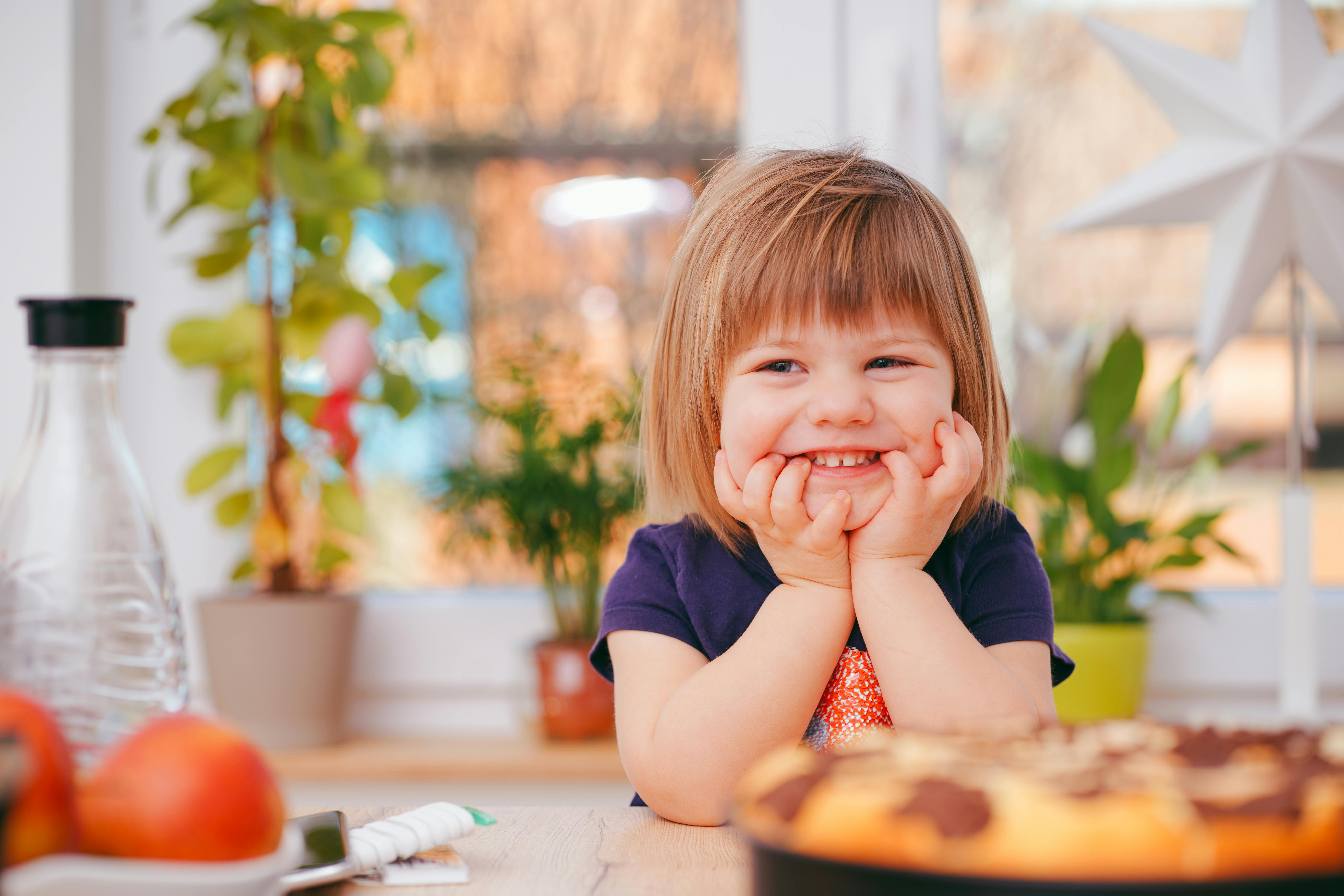 young child in a kitchen smiling