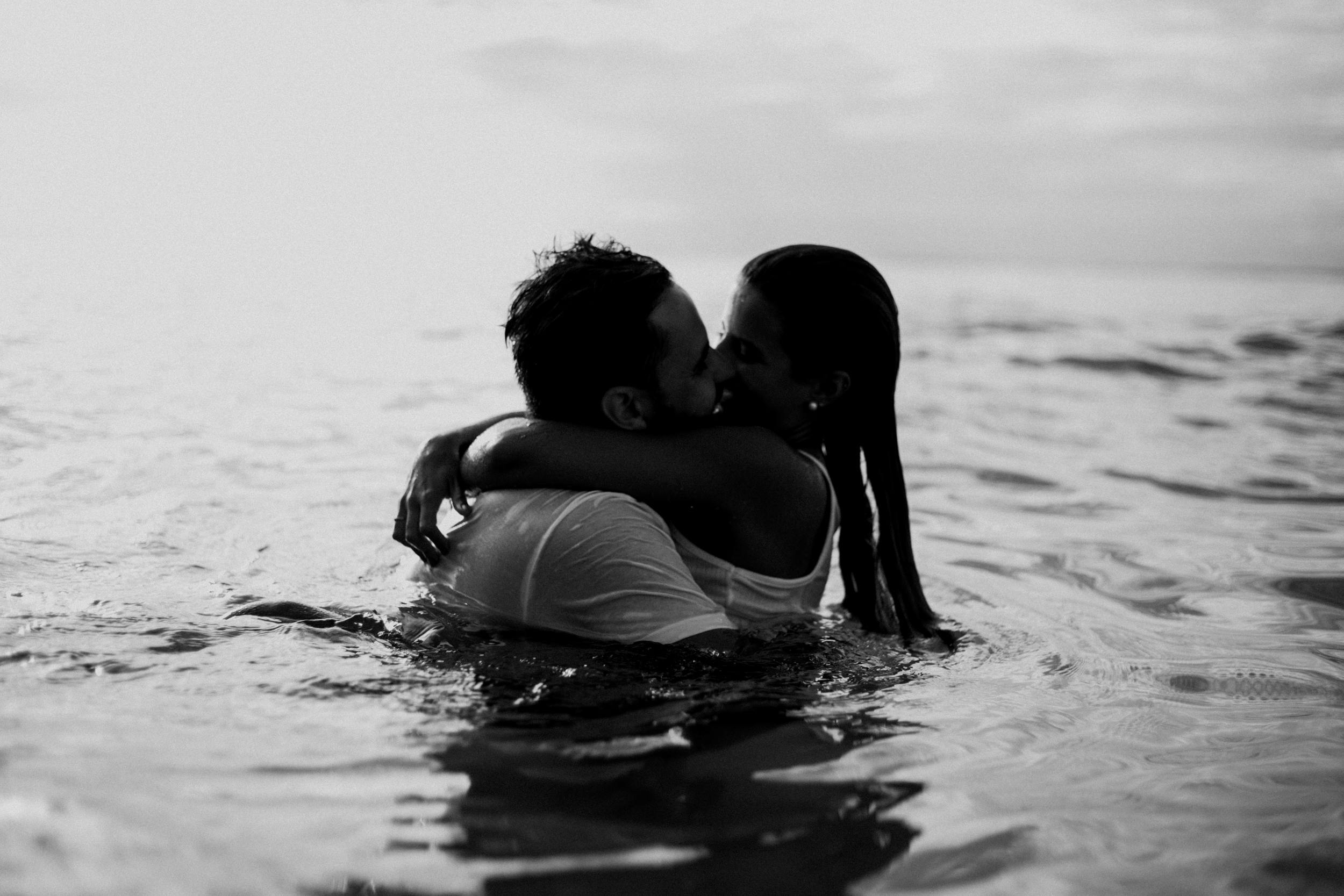 two people kissing in the water