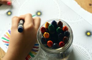 young kid drawing with crayons