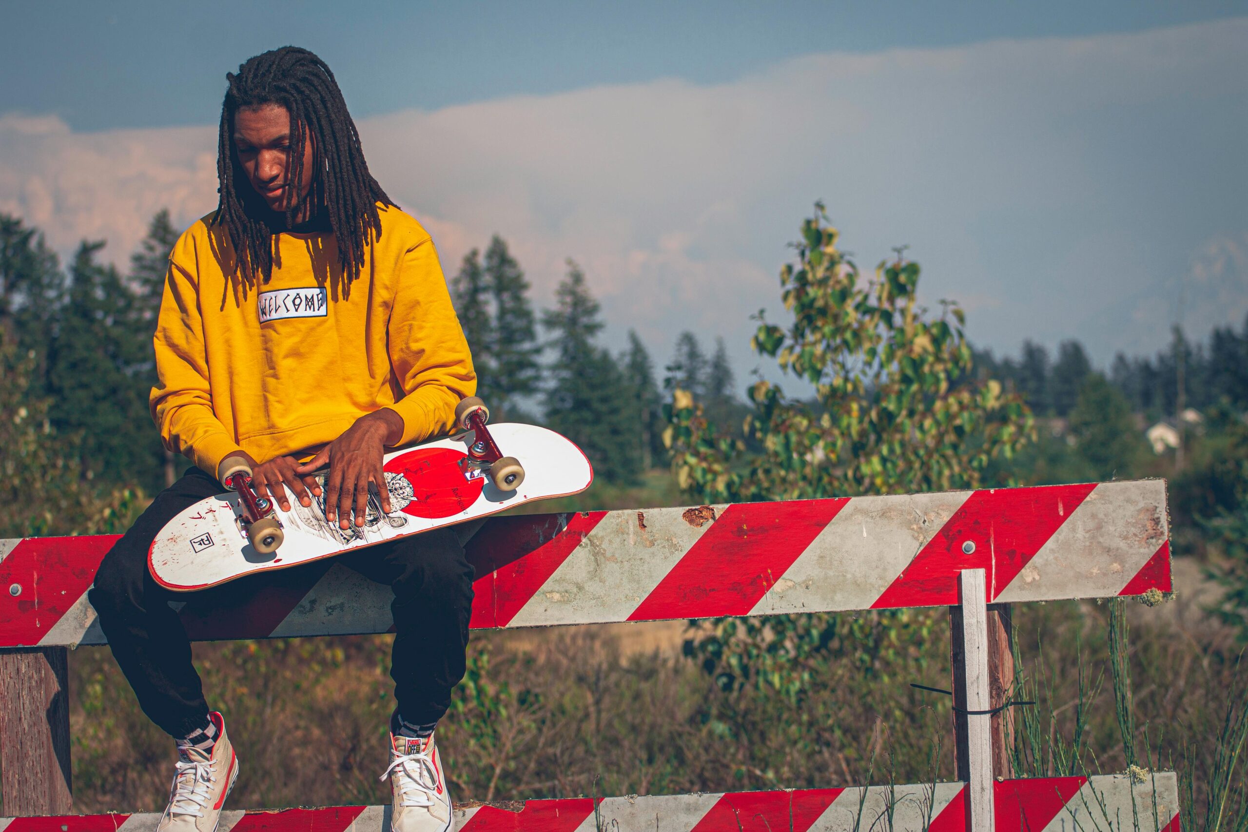 young man sitting down with skateboard