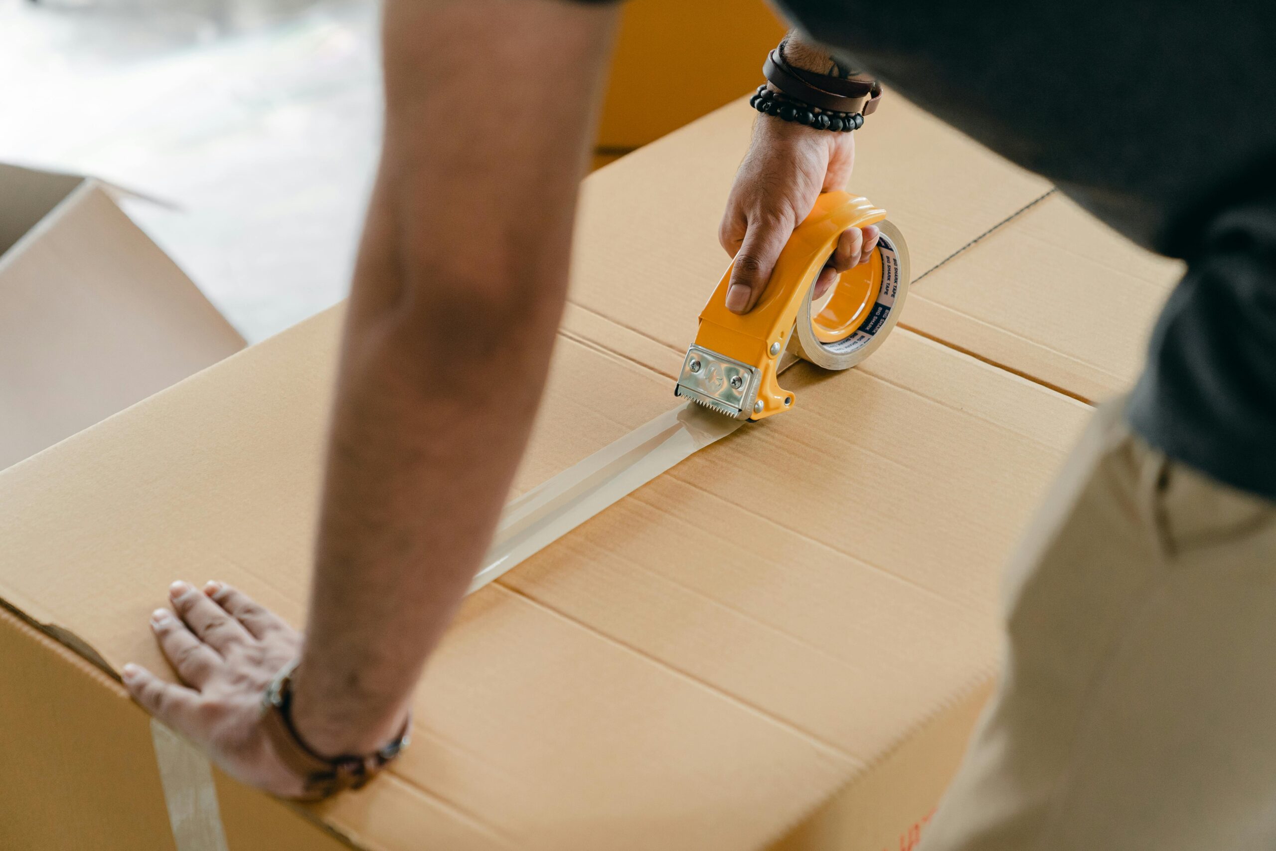 person taping up a box