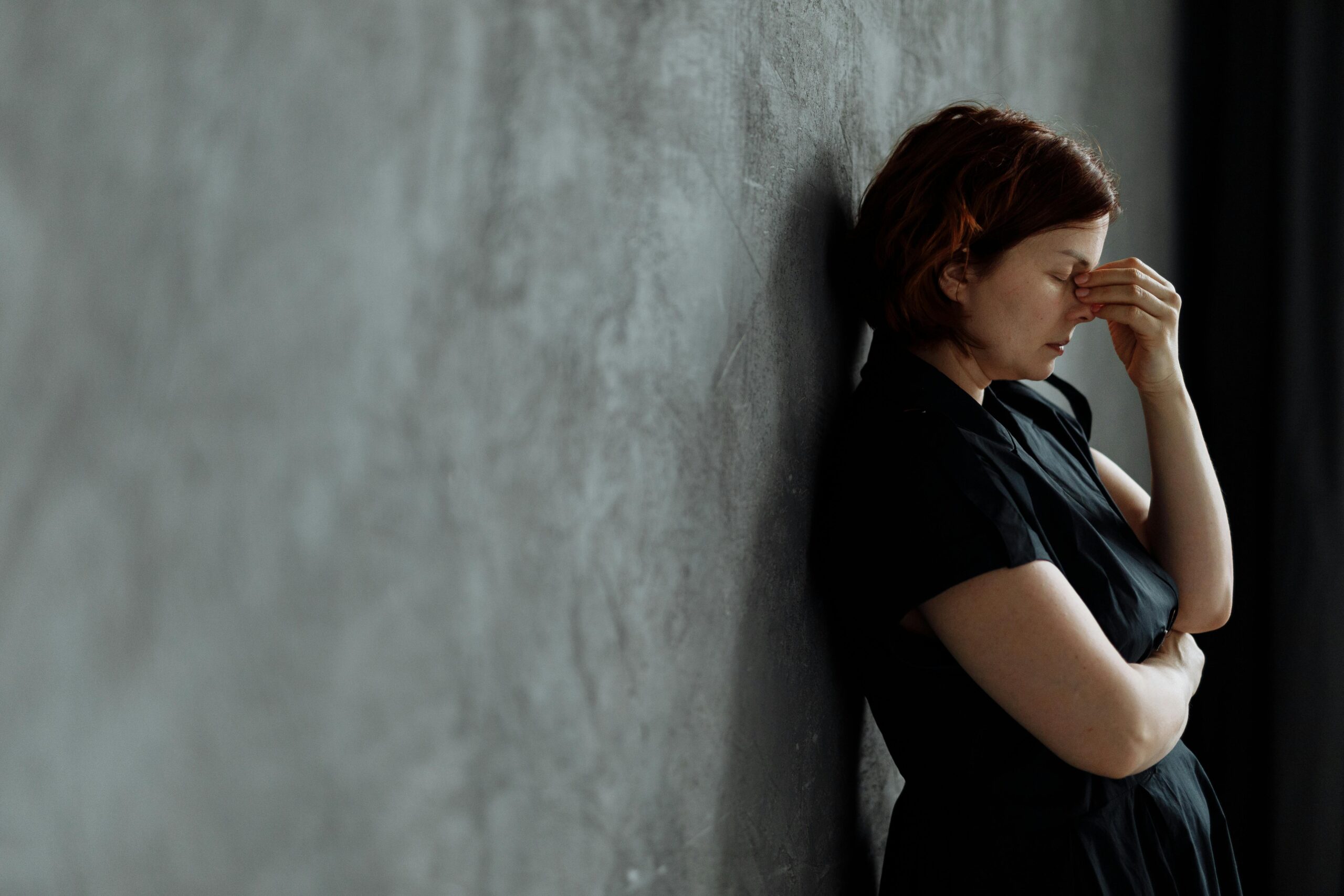 woman against wall depressed